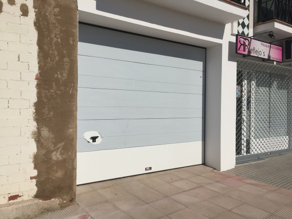 Puerta seccional comunitaria + puerta enrollable para comercio en Cartaya
